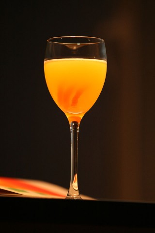 The Orange Blossom Cocktail in the goblet garnished with orange peel spiral (Коктейль Цветок Апельсина в винном бокале украшенный спиралью из кожуры апельсина)