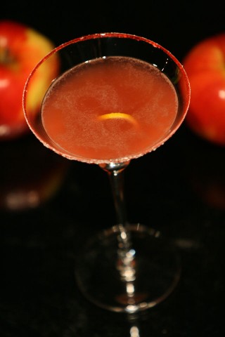 The Jack Rose Cocktail in grenadine frosted glass with apple (Коктейль Джек Роуз в коктейльном бокале с сахарной каемкой на фоне яблок)